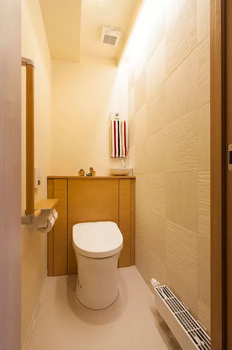 トイレは壁紙と同系食色のエコカラットと間接照明で表情をつけて