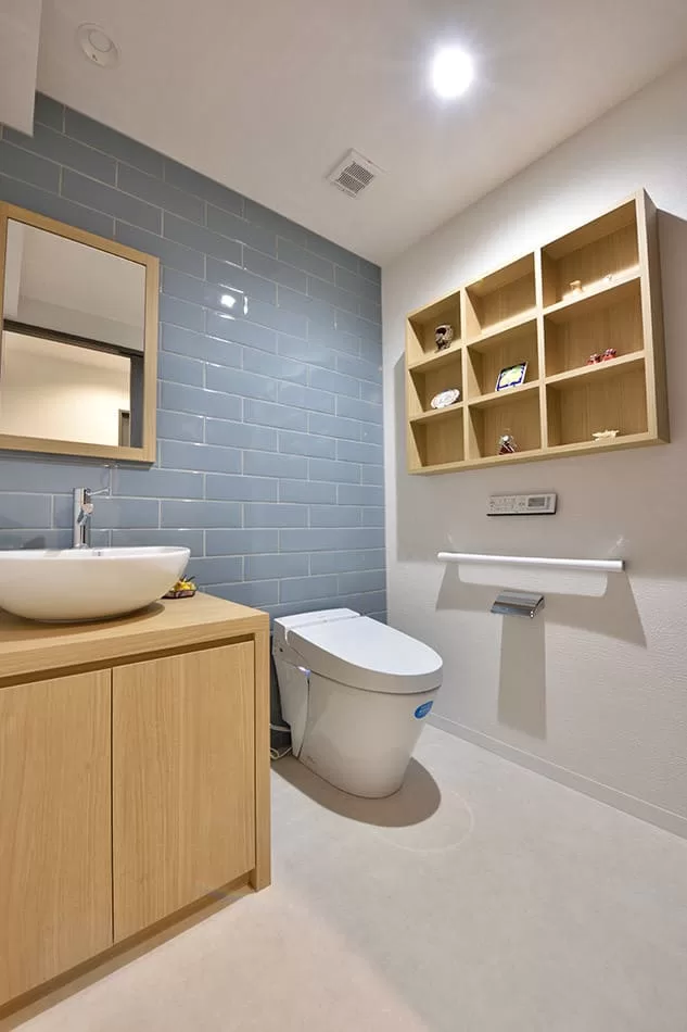 ゆったりと広く設計したトイレは、ブルー色のサブウェイタイルが空間のアクセント。手洗い器は将来洗面台としても使えるような仕様に