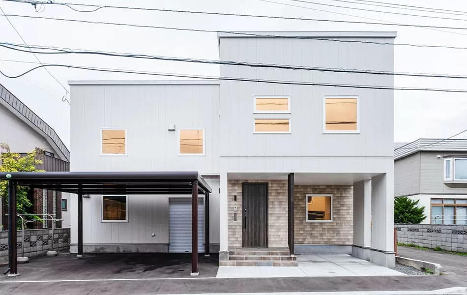 札幌市新築一戸建て白とベージュを基調にしたやさしい雰囲気の外観。横長のサッシをアクセントに用いるなど、開口レイアウトにもこだわった。建物の前には3台分の駐車スペースを確保